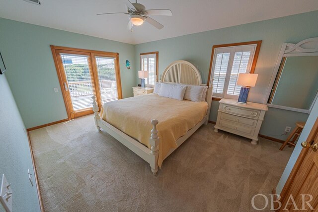 bedroom featuring light carpet, multiple windows, baseboards, and access to exterior