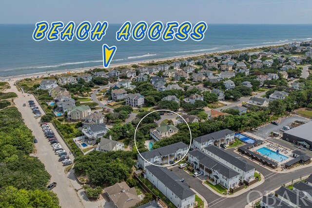 bird's eye view featuring a beach view, a water view, and a residential view