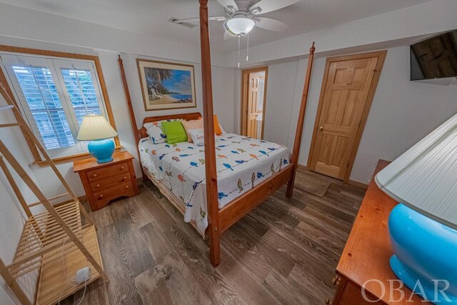 bedroom featuring ceiling fan, visible vents, baseboards, and dark wood-type flooring