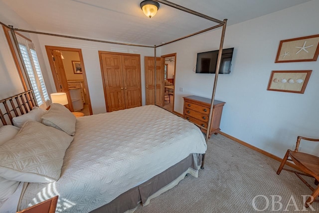 bedroom with a closet, light carpet, connected bathroom, and baseboards