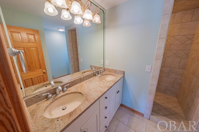 full bathroom with double vanity, a sink, and tile patterned floors