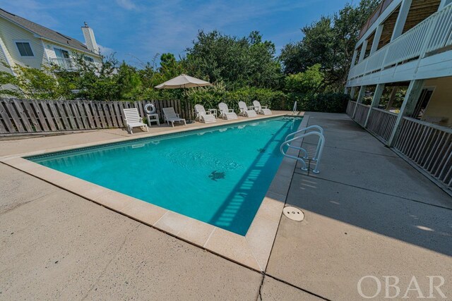 view of swimming pool featuring a patio area, fence, and a fenced in pool