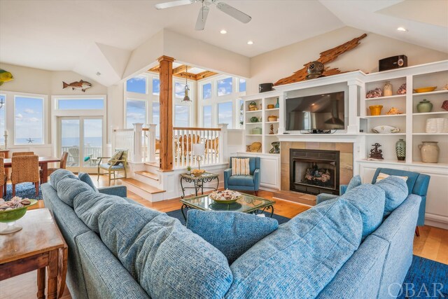 living room featuring recessed lighting, light wood-style flooring, a tiled fireplace, vaulted ceiling, and ceiling fan