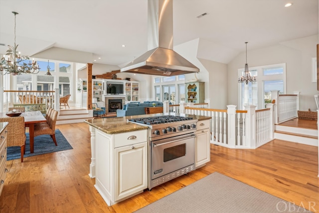 kitchen with island exhaust hood, a chandelier, open floor plan, and luxury stove