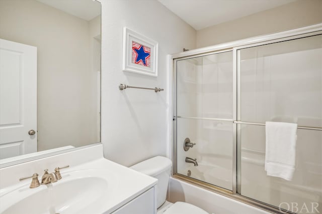 bathroom with shower / bath combination with glass door, vanity, and toilet