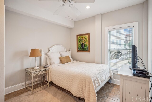 bedroom with ceiling fan, multiple windows, and baseboards