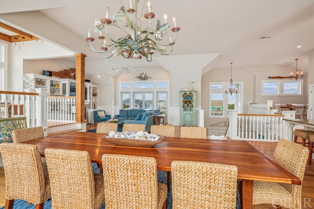 dining room with lofted ceiling, ornate columns, wood finished floors, and ceiling fan with notable chandelier