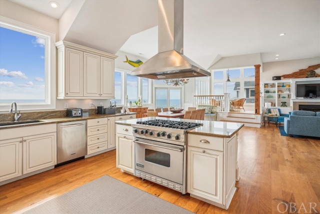 kitchen featuring light wood-style flooring, a sink, open floor plan, appliances with stainless steel finishes, and island exhaust hood