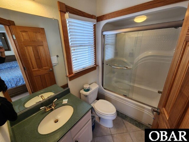 full bath featuring toilet, tile patterned floors, enclosed tub / shower combo, and vanity