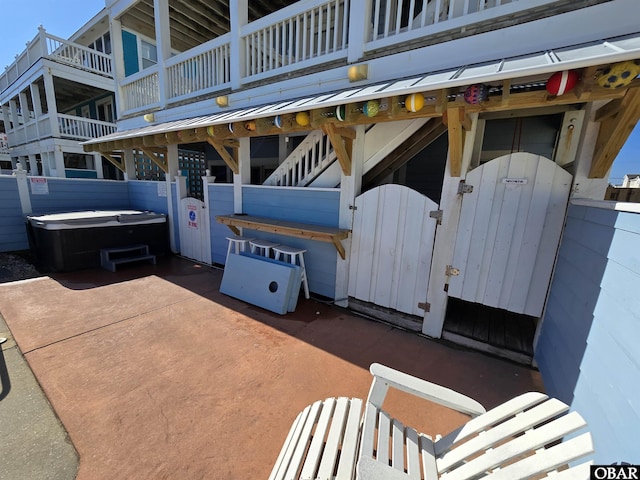 view of patio with a gate and a hot tub