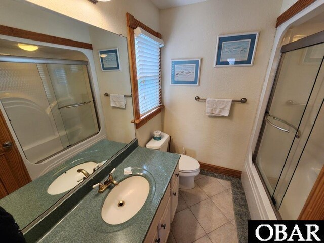 bathroom with baseboards, vanity, toilet, and tile patterned floors