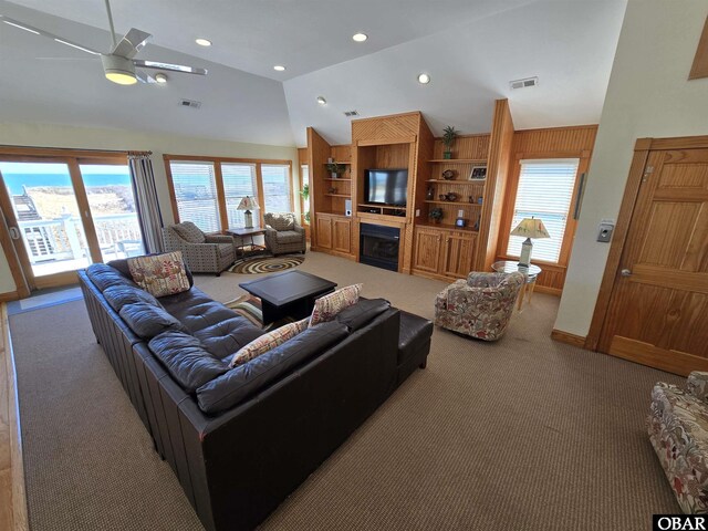 carpeted living room with vaulted ceiling, a fireplace, visible vents, and recessed lighting