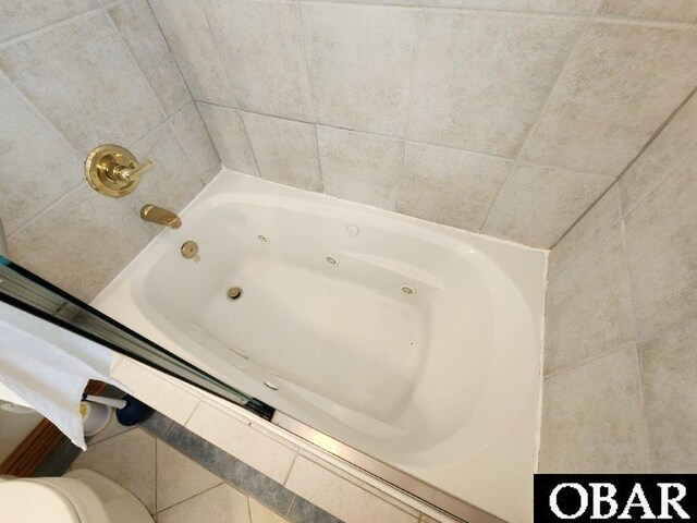 full bath featuring toilet and a tub with jets