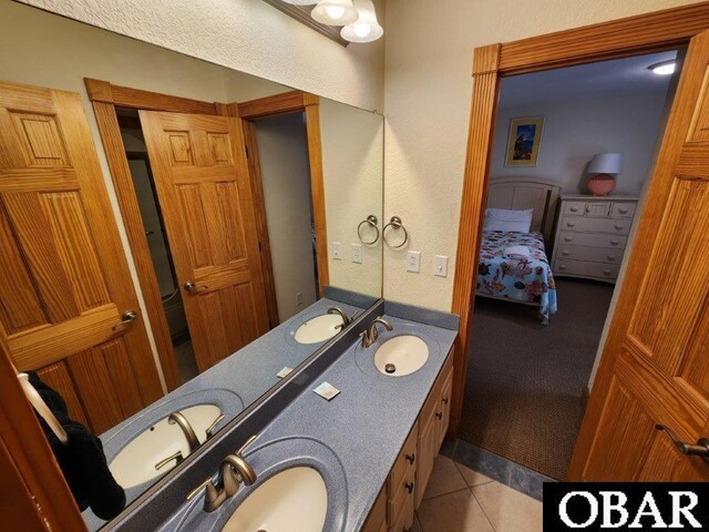 ensuite bathroom with tile patterned flooring, a sink, and ensuite bath