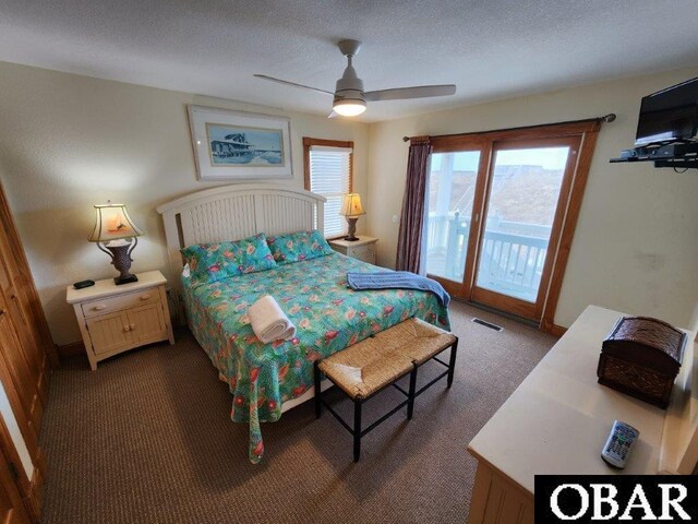 bedroom with access to exterior, dark colored carpet, visible vents, a ceiling fan, and a textured ceiling