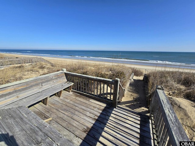 surrounding community featuring a water view and a beach view