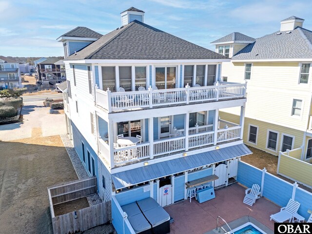 rear view of property featuring a shingled roof, a patio area, a balcony, a residential view, and a fenced backyard