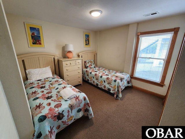 bedroom featuring dark carpet, visible vents, and baseboards