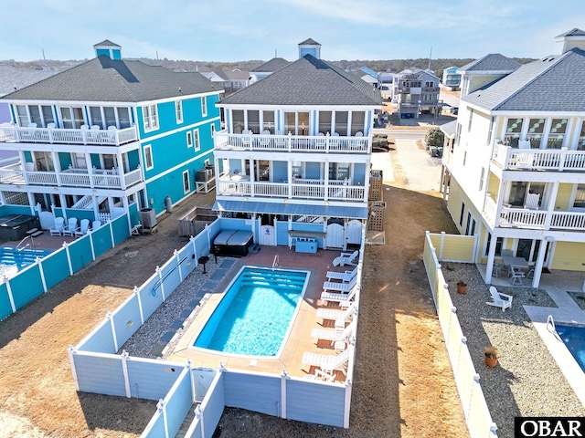 back of house with a patio area, a fenced backyard, a residential view, and a community pool