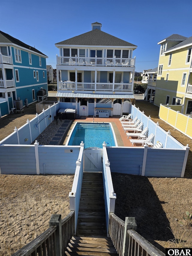 community pool featuring a fenced backyard, a residential view, and central air condition unit