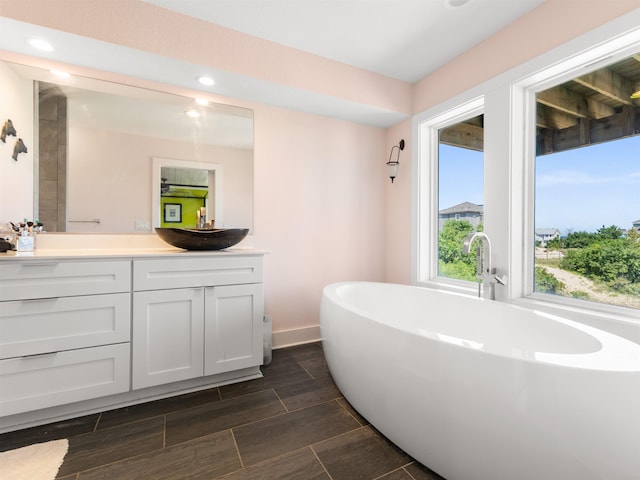 1556 Sandpiper Rd Lot # 33, Corolla, NC 27927 - bathroom featuring a freestanding tub, vanity, recessed lighting, wood tiled floor, and baseboards