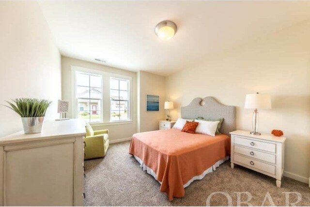 bedroom with baseboards and light colored carpet