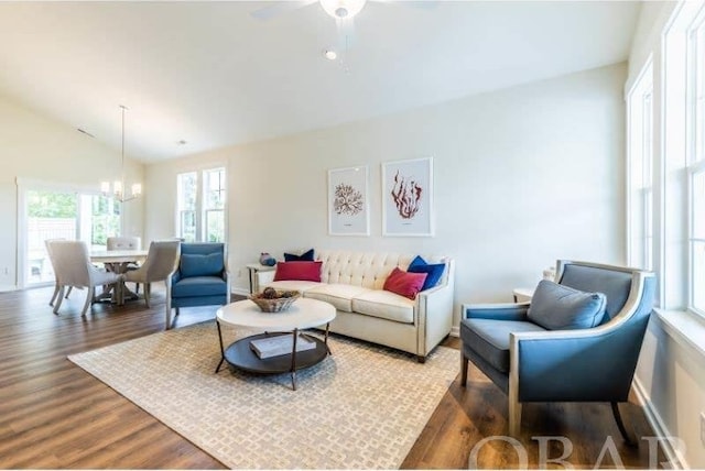 living room with lofted ceiling, dark wood-type flooring, and a chandelier