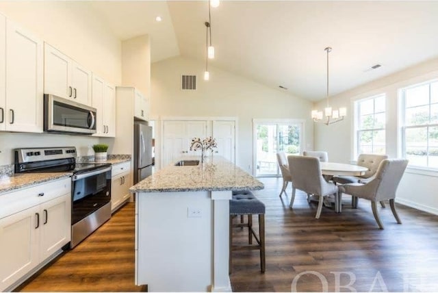 kitchen featuring visible vents, a kitchen island with sink, appliances with stainless steel finishes, and white cabinets