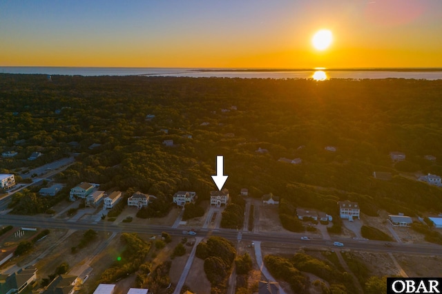 aerial view at dusk featuring a water view