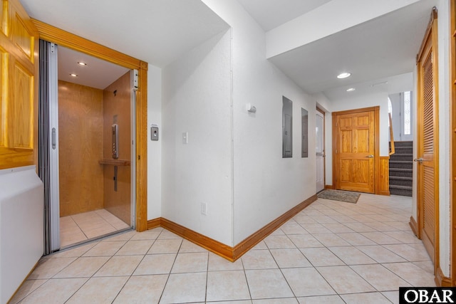 hall with light tile patterned floors, baseboards, elevator, and recessed lighting