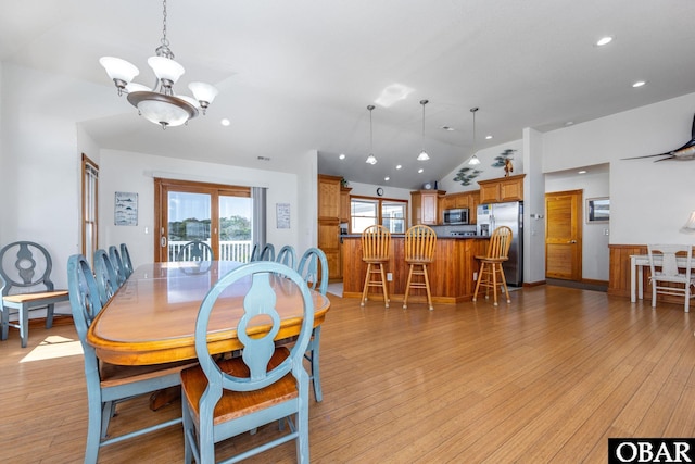 dining area featuring light wood-style floors, lofted ceiling, recessed lighting, and an inviting chandelier