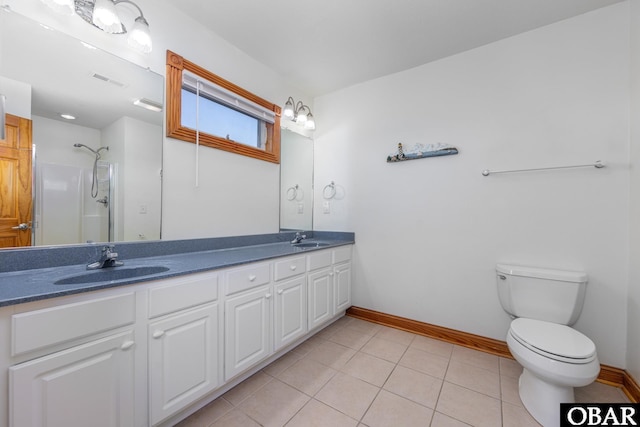 bathroom with double vanity, tile patterned flooring, baseboards, and a sink