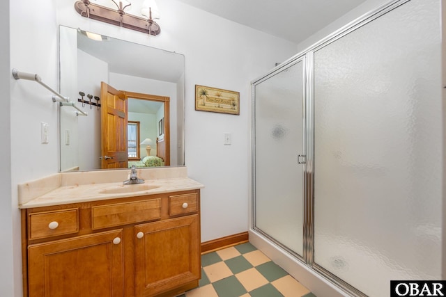 ensuite bathroom with a stall shower, connected bathroom, vanity, and tile patterned floors