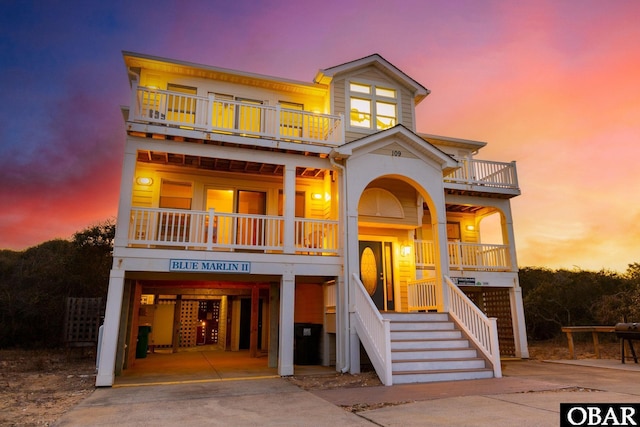 coastal inspired home featuring a carport, a balcony, and driveway