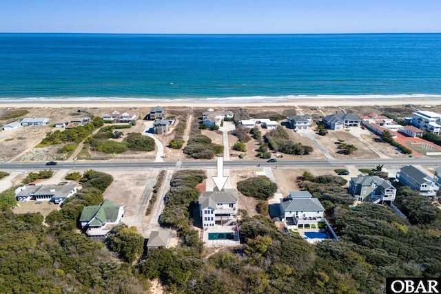 drone / aerial view with a residential view, a water view, and a beach view