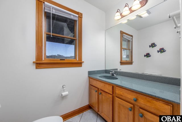 half bathroom featuring toilet, baseboards, vanity, and tile patterned floors