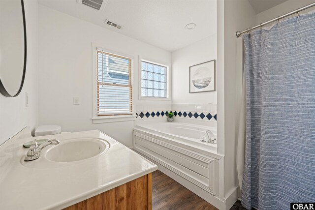 bathroom with curtained shower, visible vents, vanity, and wood finished floors