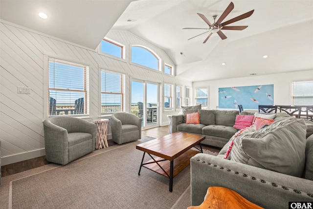 living room with lofted ceiling, a ceiling fan, a wealth of natural light, and a city view