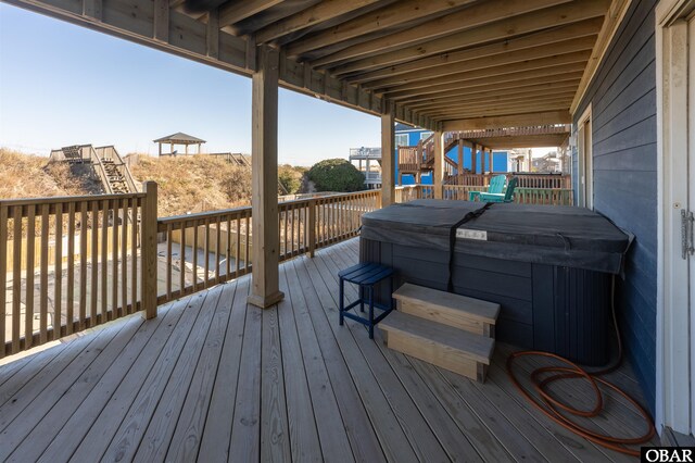 wooden terrace with stairs and a covered hot tub