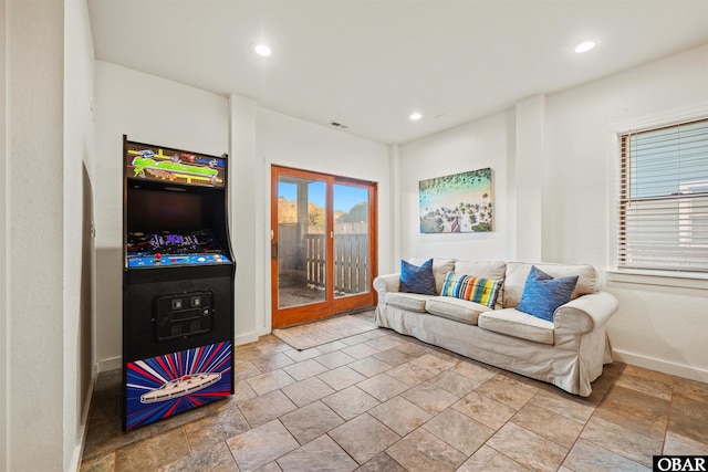 living area featuring recessed lighting, french doors, stone finish flooring, and baseboards