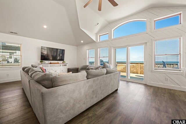 living area with dark wood-style floors, ceiling fan, visible vents, and high vaulted ceiling