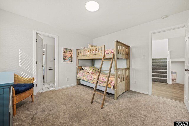 bedroom featuring light carpet and baseboards