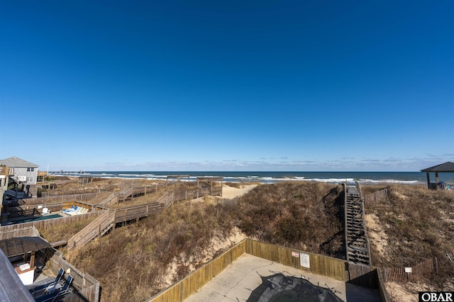 water view featuring a view of the beach and fence private yard