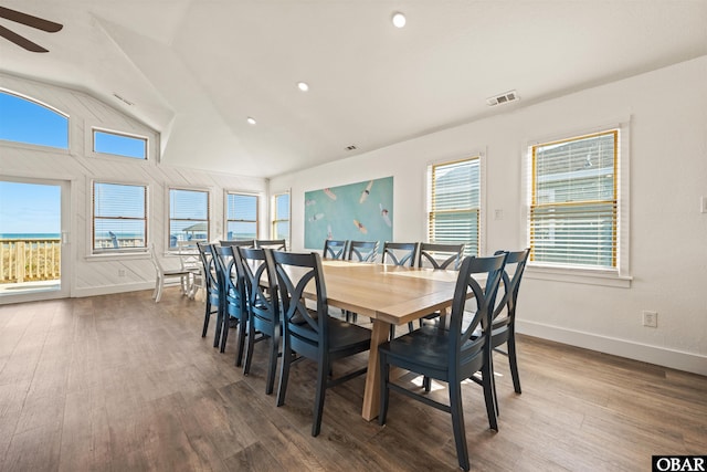 dining area featuring visible vents, baseboards, a ceiling fan, wood finished floors, and vaulted ceiling