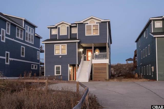 raised beach house featuring covered porch and stairs