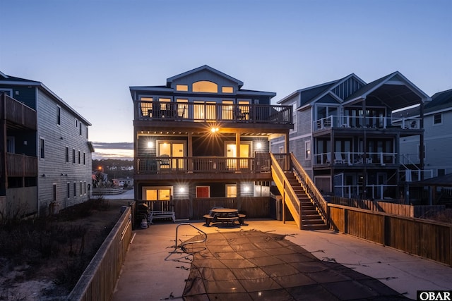 back of house featuring stairway, a patio area, fence, and a balcony