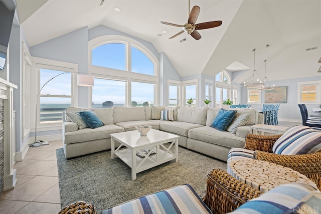 living room with visible vents, a water view, light tile patterned flooring, high vaulted ceiling, and ceiling fan with notable chandelier