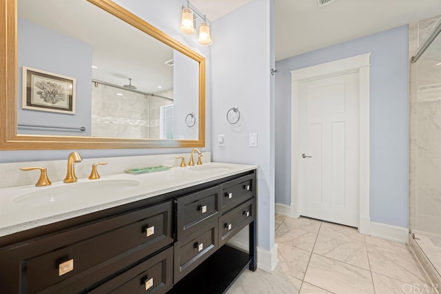 full bath with marble finish floor, a sink, and a shower stall