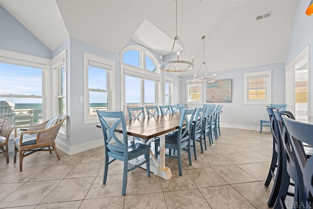 dining area with a wealth of natural light, a water view, and light tile patterned flooring