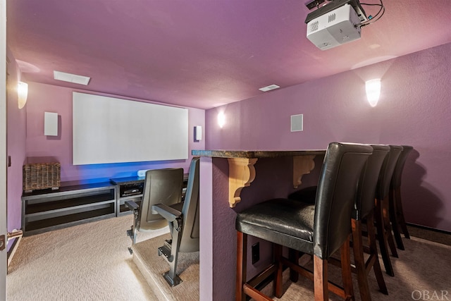 home theater room with a dry bar, carpet, and visible vents